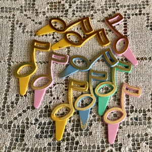 May include: A set of nine colorful plastic musical note cake toppers. The notes are outlined in gold and have a vintage look. The colors include pink, yellow, blue, and green.