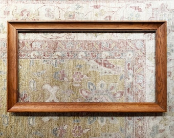 May include: A brown wooden picture frame with a simple design. The frame is empty and ready to be filled with a photo or artwork.