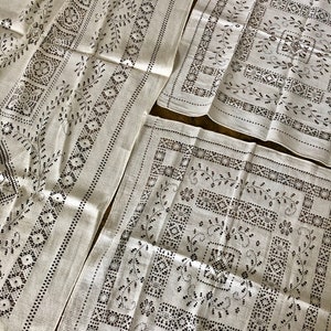 Peut inclure: Ensemble de trois nappes en lin blanc avec un motif floral brod&eacute; noir.