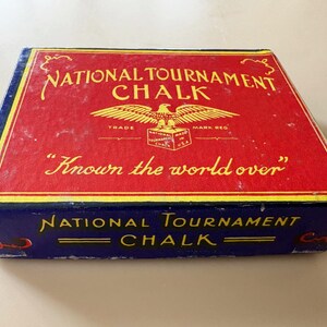 K&ouml;nnte beinhalten: Rechteckige Schachtel mit "National Tournament Chalk" mit roter Oberseite und blauen Seiten. Die Oberseite zeigt goldfarbene Schrift und ein Adleremblem. Der Text "Known the world over" ist ebenfalls sichtbar.