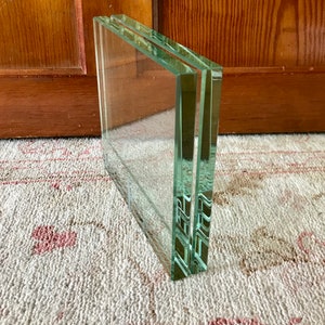 May include: A stack of three clear glass picture frames.