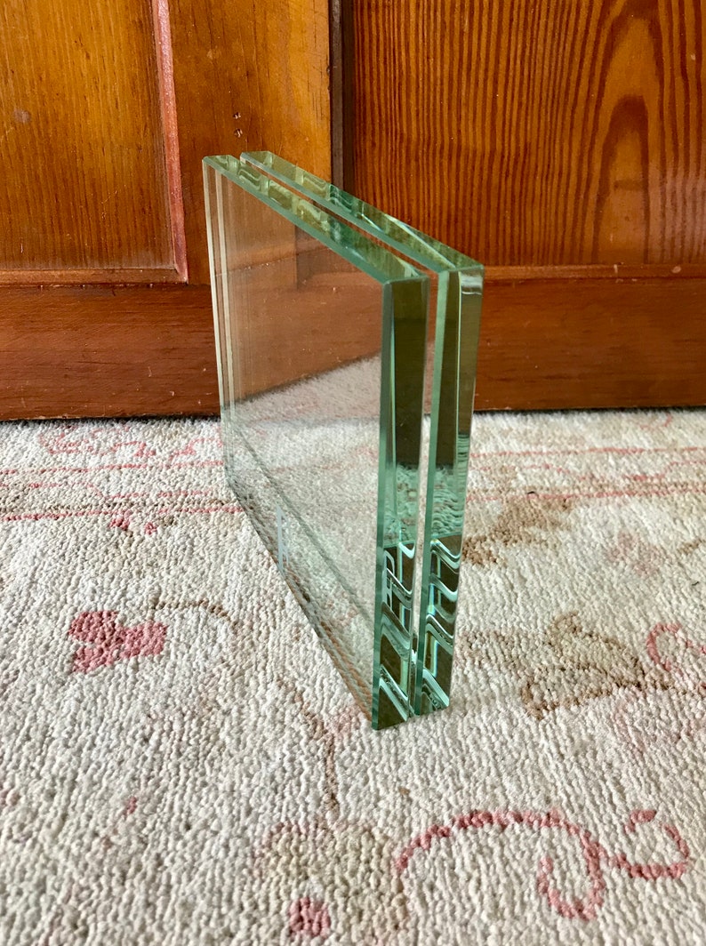 May include: A stack of three clear glass picture frames.