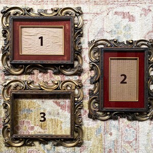 May include: Three ornate gold picture frames with red mats and numbers 1, 2, and 3 in the center of each frame.