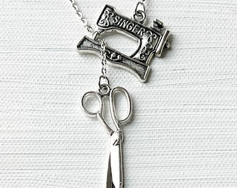 May include: Silver necklace with a sewing machine charm and a pair of scissors charm. The sewing machine charm has the word "SINGER" on it.