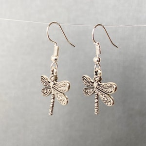 Può includere: Orecchini a forma di libellula in argento con un design dettagliato. Gli orecchini hanno una chiusura a gancio.