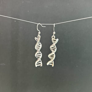 Puede incluir: Un par de pendientes colgantes de plata con un diseño de ADN de doble hélice.