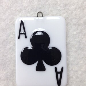 May include: A white glass ornament shaped like a playing card with a black ace of clubs design.