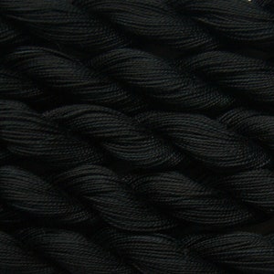 May include: Close-up of black embroidery floss, a type of thread used for hand sewing and embroidery.