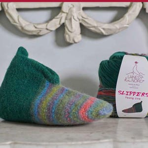 Puede incluir: Pantuflas de lana verde y multicolor con un degradado de colores. Las pantuflas están hechas por Laines du Nord, una marca de hilo hecha en Italia. El hilo se muestra en una bola junto a las pantuflas. El texto en la etiqueta dice "Laines du Nord" y "Slippers Young Line".