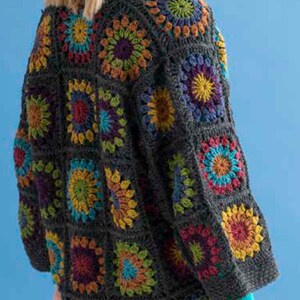 May include: A dark grey crochet jacket with colourful floral squares. The jacket has a relaxed fit with long sleeves and a collar. The squares are in shades of red, yellow, blue, and green, creating a vibrant design. The jacket is a handmade garment.