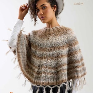 Può includere: Un poncho in maglia soffice con strisce orizzontali nei toni del marrone, beige e crema. Il capo presenta uno scollo a coste e un orlo decorato con lunghe nappe sfrangiate. Sono presenti le scritte ROMY JL2026-35 e JODY LONG LOFT & LOOP COLLECTION.