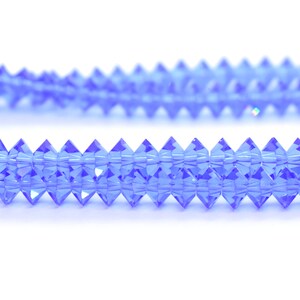 May include: A strand of light blue crystal beads with a faceted, pointed shape.