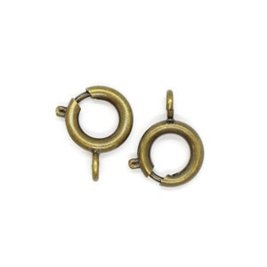 May include: Two antique gold-toned metal clasp rings for jewelry making.