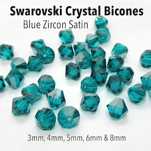 May include: Assortment of teal blue Swarovski crystal bicones in various sizes, including 3mm, 4mm, 5mm, 6mm, and 8mm. The bicones have a satin finish.