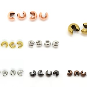 May include: Assortment of crimp end bead caps in various finishes, including gold, silver, rose gold, antique brass, and black. These caps are used to secure the ends of cords, strings, or chains.