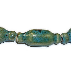May include: Three ceramic beads in shades of green and blue with a speckled glaze. The beads are cylindrical and have a slightly rounded shape.