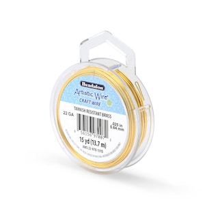 May include: A spool of Beadalon Artistic Wire in a clear plastic container. The wire is a bright gold color, labeled as 22 gauge, and 0.025 inches (0.64 mm) thick. The label indicates 15 yards (13.7 m) of tarnish-resistant brass wire.