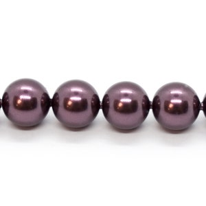 May include: A strand of dark purple round beads. The beads are smooth and shiny.