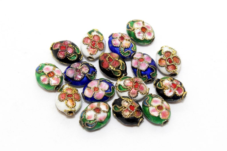 May include: A collection of oval-shaped beads with floral designs. The beads are painted in various colours, including white, black, blue, green, and pink. The flowers are painted in shades of pink and white.