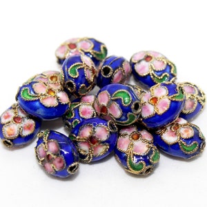 May include: A collection of oval-shaped beads with a blue enamel base and floral designs in pink, white, and green. The beads have a gold trim.