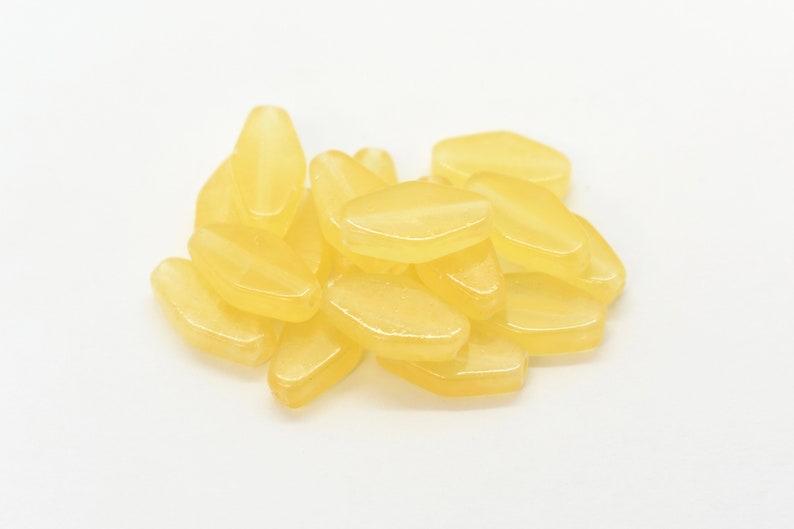 May include: A pile of yellow lemon-shaped sweets.