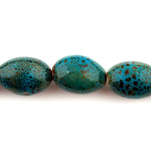 May include: A string of oval-shaped turquoise blue ceramic beads with a speckled brown pattern.