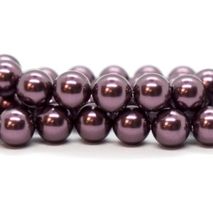 May include: A strand of dark purple pearl beads. The beads are round and have a smooth, glossy finish.