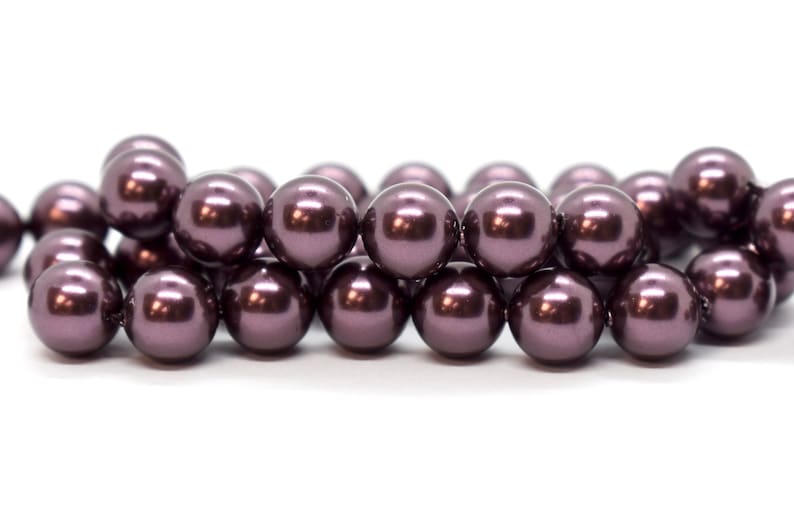 May include: A strand of dark purple pearl beads. The beads are round and have a smooth, glossy finish.