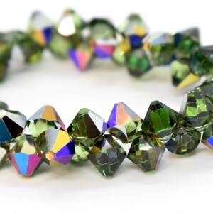 May include: A strand of green faceted crystal beads with iridescent rainbow accents. The beads are strung on a clear thread.