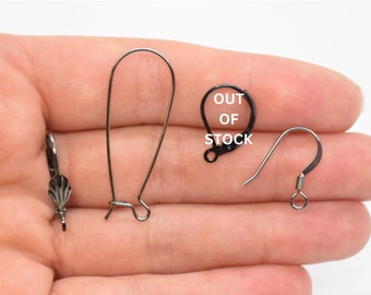 May include: Three different styles of earring hooks. The first is a silver-toned, teardrop-shaped hook. The second is a black, teardrop-shaped hook. The third is a silver-toned, leverback hook.