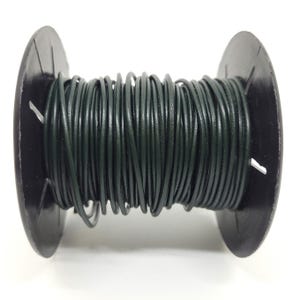 May include: A spool of dark green floral wire. The wire is tightly wound around a black plastic spool. The image is a close-up shot, highlighting the texture and color of the wire, suitable for crafting and floral arrangements.