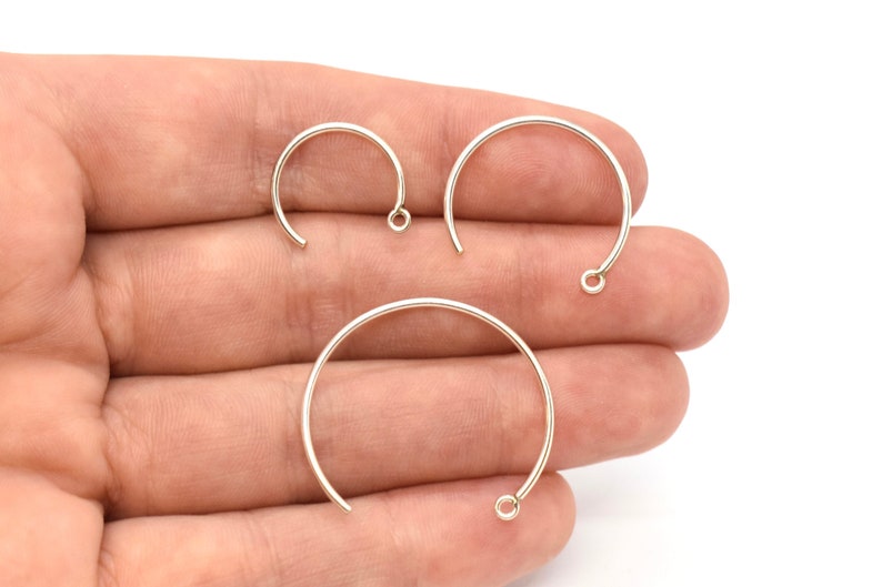 May include: Three silver jump rings of different sizes. The rings are open and have a small loop at the top.