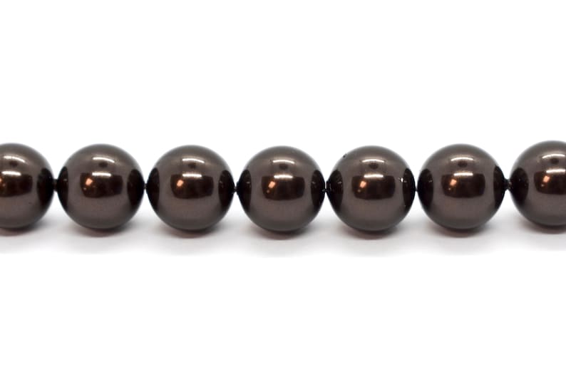May include: A strand of dark brown round pearls.