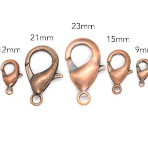 May include: Five antique copper-toned lobster clasps in various sizes: 9mm, 12mm, 15mm, 21mm, and 23mm.