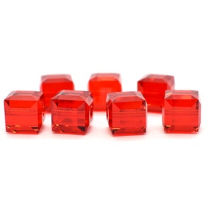 May include: Eight red square glass beads with a faceted design.