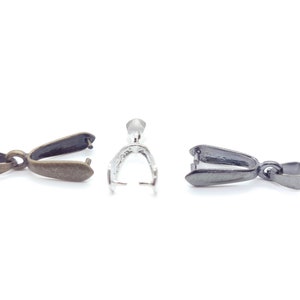 May include: Three pendant clasps in different finishes: antique brass, silver, and black. Each clasp has a loop at the top and a flat, oval-shaped base.