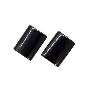 Peut inclure: Une paire de boucles d'oreilles rectangulaires noires. Les boucles d'oreilles sont en mat&eacute;riau lisse et brillant.