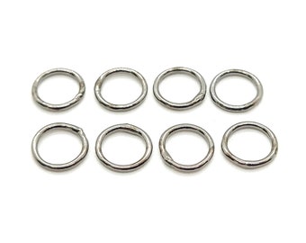 May include: Eight silver jump rings, each with a circular shape and a smooth, polished finish.
