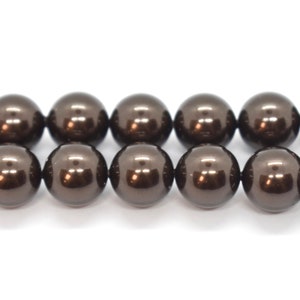 May include: A strand of dark brown round beads with a glossy finish.