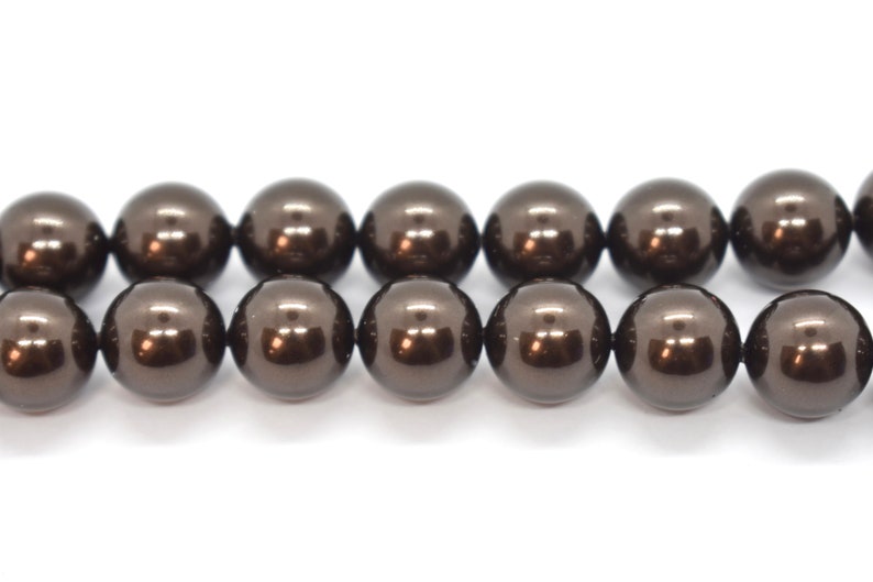 May include: A strand of dark brown round beads with a glossy finish.