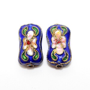May include: Two blue enamel beads with gold trim and white and pink floral designs.
