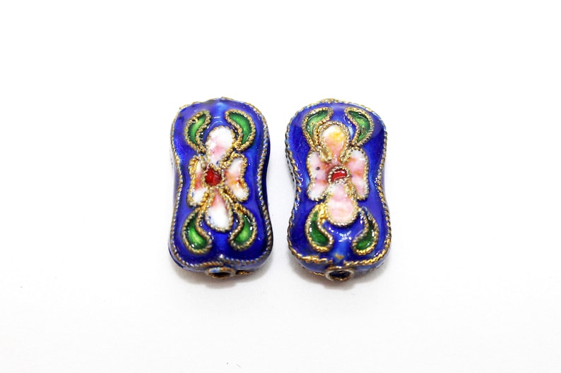 May include: Two blue enamel beads with gold trim and white and pink floral designs.