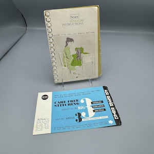 May include: A vintage sewing machine instruction booklet with a spiral binding. The cover features a cartoon illustration of a woman and a girl sewing. The booklet is titled "Sears Kenmore Instructions Model 1774 - Zig-Zag Sewing Machine". A smaller card with the text "Care Free Stitching depends on the BIG 3 and the LITTLE 3" is also shown.