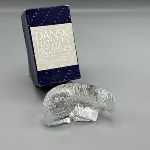 Puede incluir: Una figurita de oveja de vidrio transparente de la colección Dansk Nativity Figurines. La figurita está hecha de cristal de plomo completo y forma parte de un conjunto de nacimiento más grande. La caja de la figurita está en el fondo.