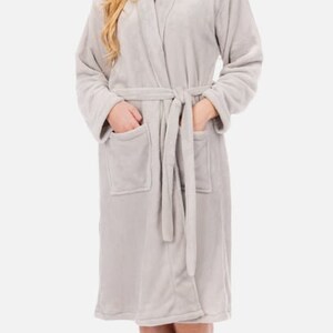 May include: A soft, gray robe with a shawl collar and a tie belt. The robe has two pockets and is made of a plush material.