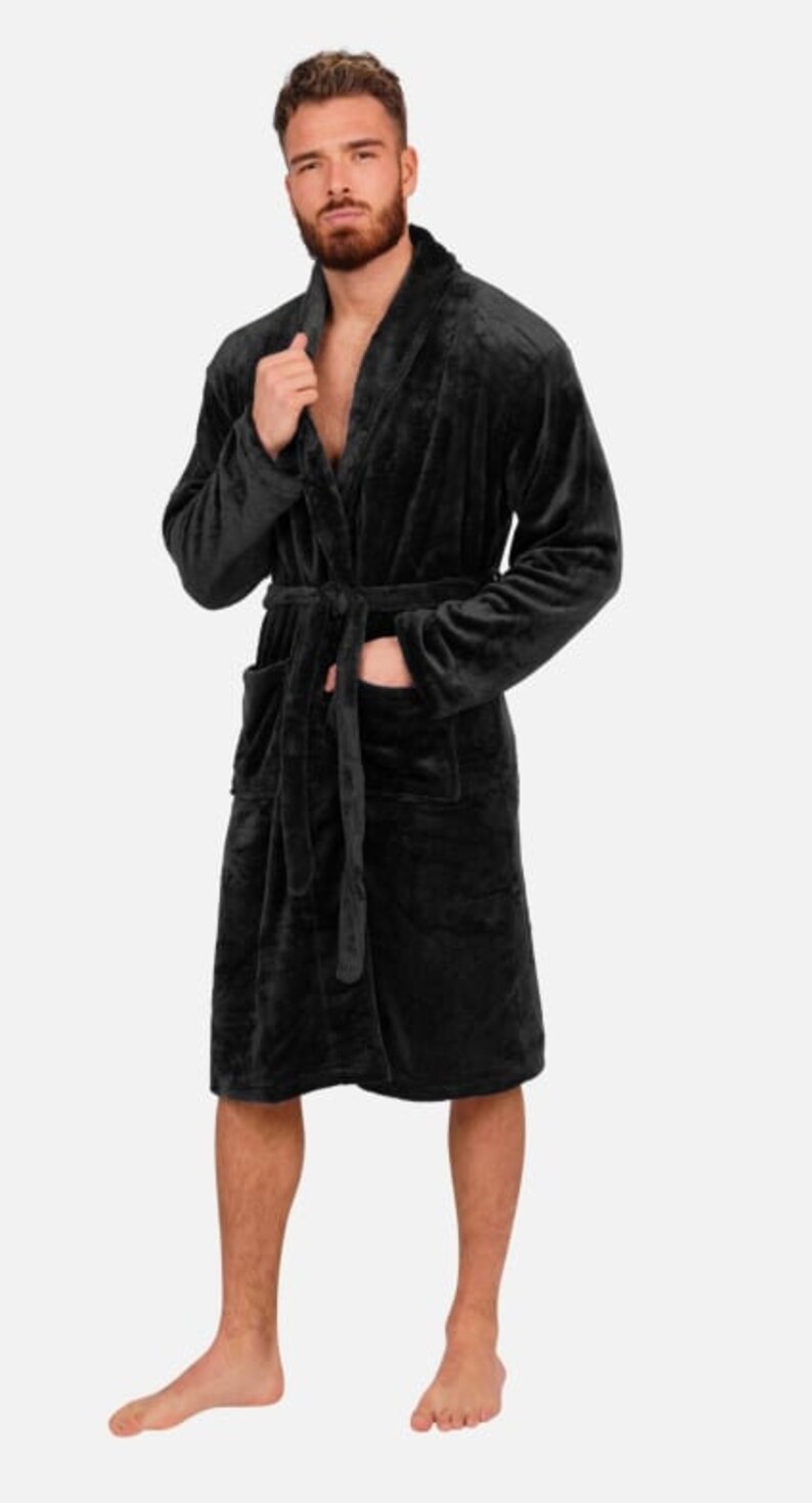 May include: A black plush robe with a shawl collar and a tie belt. The robe has two pockets on the front.