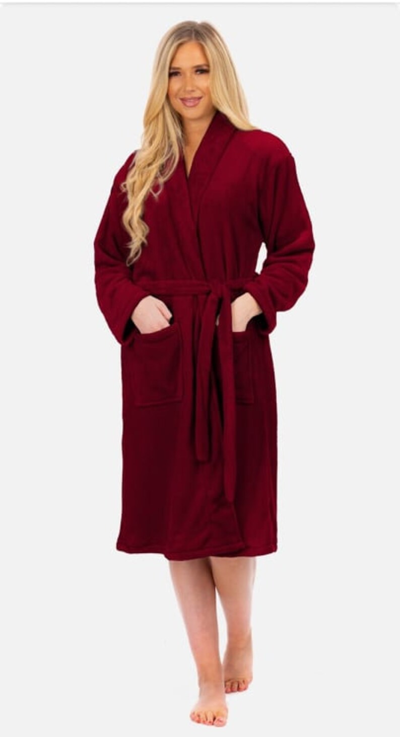 May include: A long-sleeved, burgundy robe with a shawl collar and a tie belt. The robe has two pockets on the front.