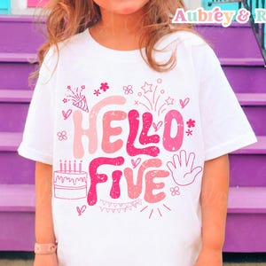 Puede incluir: Camiseta blanca con un diseño gráfico rosa y blanco que dice "Hello Five" con un pastel de cumpleaños, fuegos artificiales y confeti.