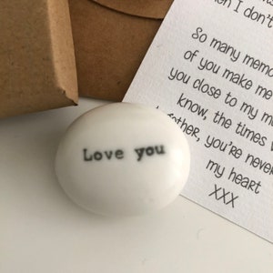 May include: White ceramic stone with the words "Love you" written in black.