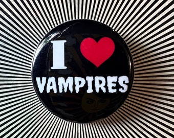 May include: A black and white button with a red heart and the text "I love Vampires".